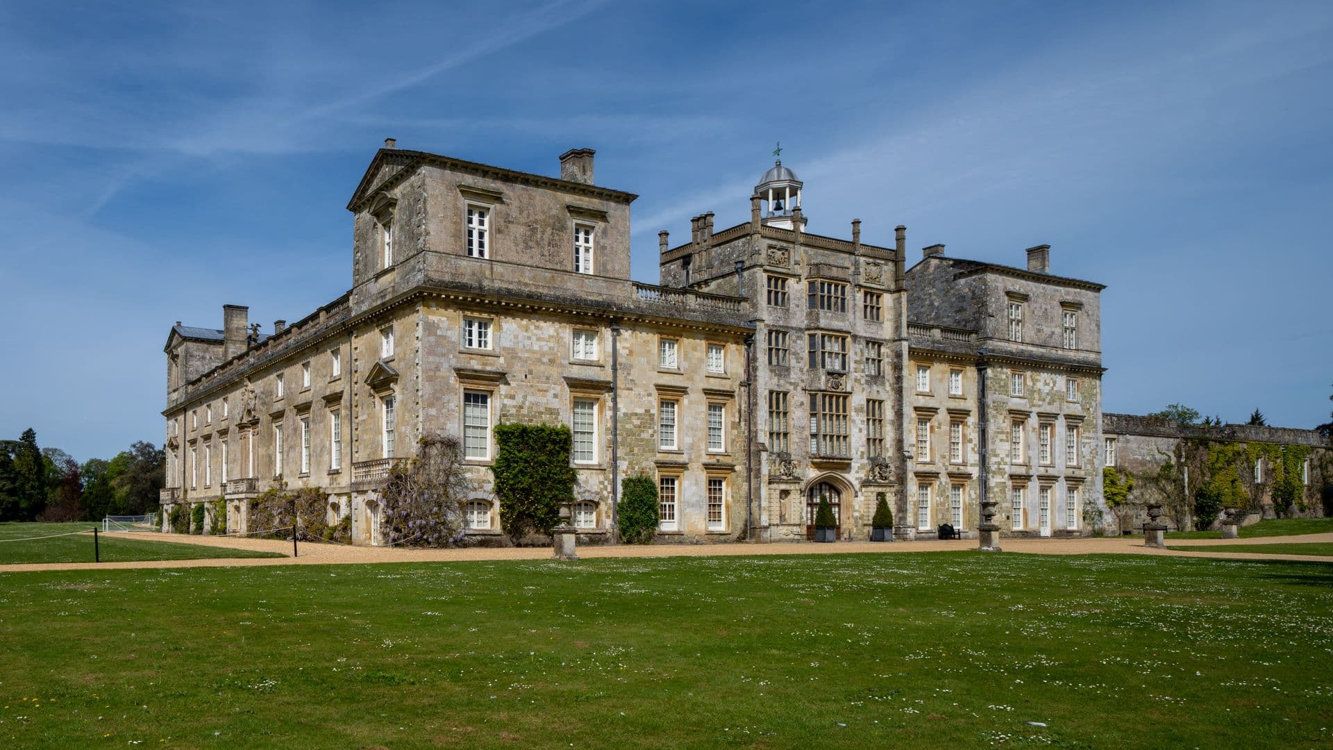 A stone country house across formal lawns